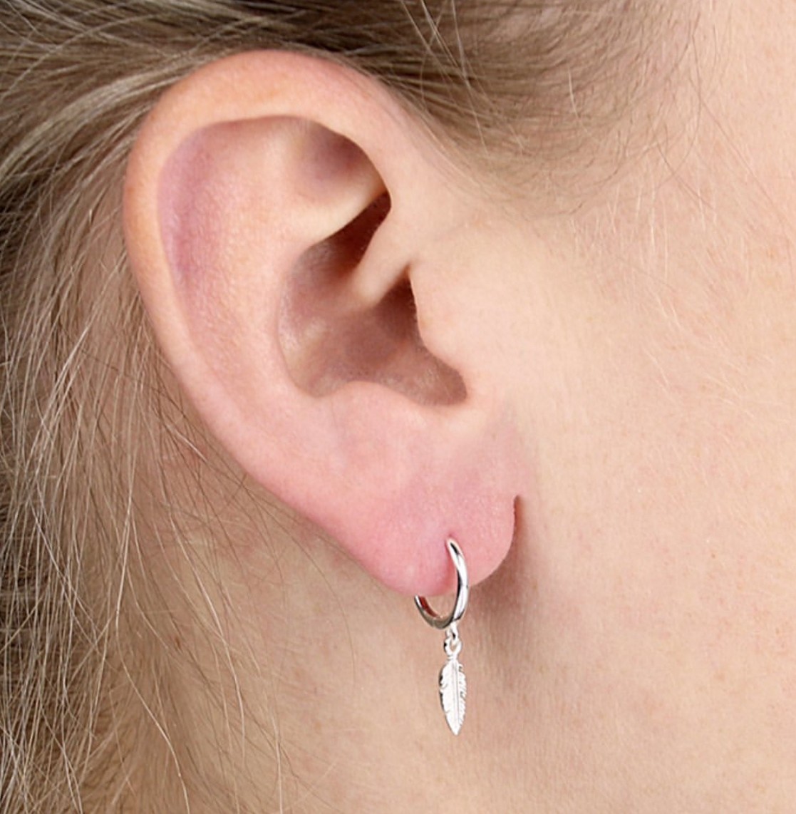 Sterling Silver Feather Charm Huggie Hoops Sterling Silver Feather Charm Huggie Hoop being worn.